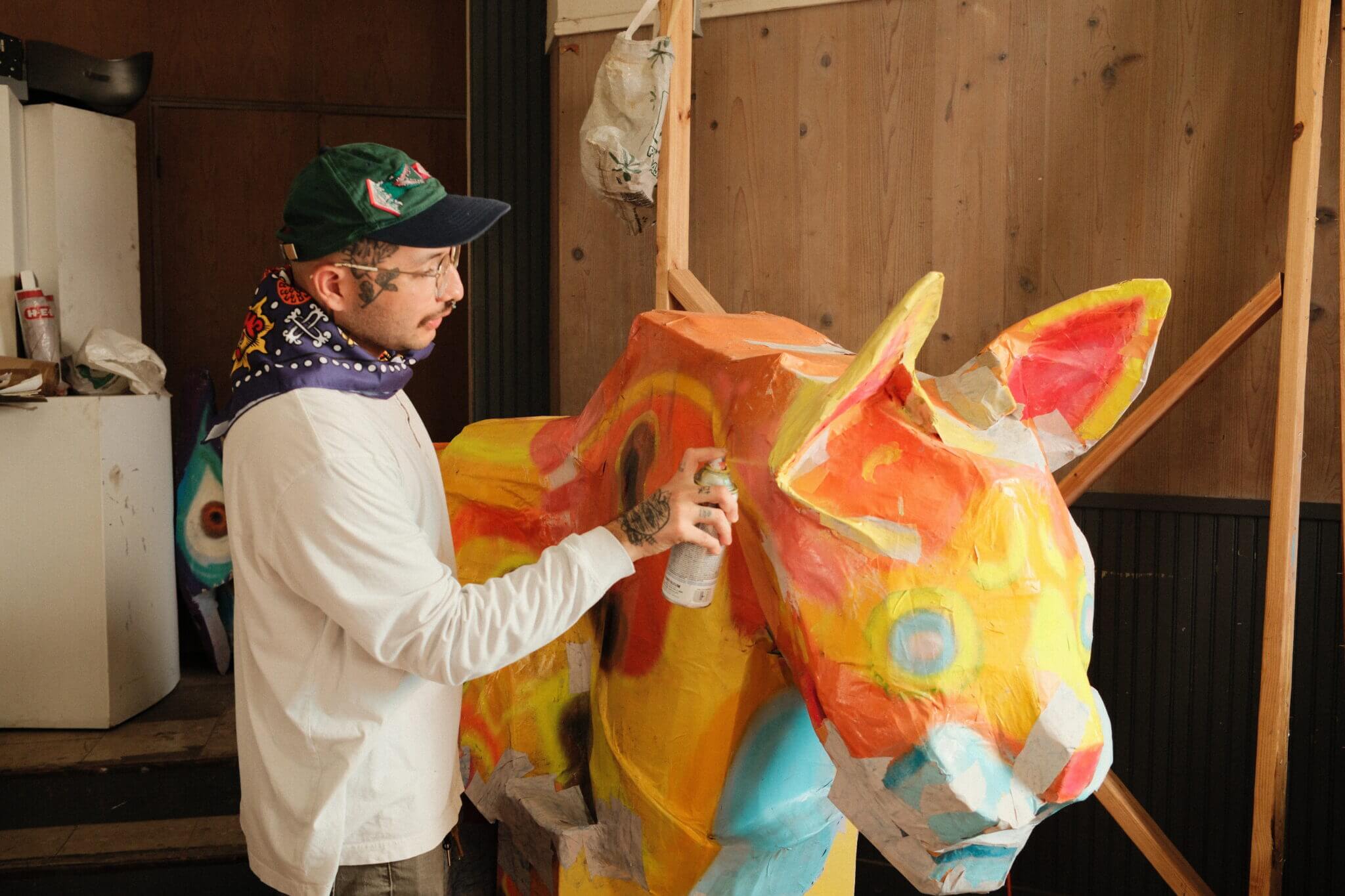 San Antonio artist Mauro de la Tierra in his studio near Pearl spray painting an Ocelot Alebrije statue.